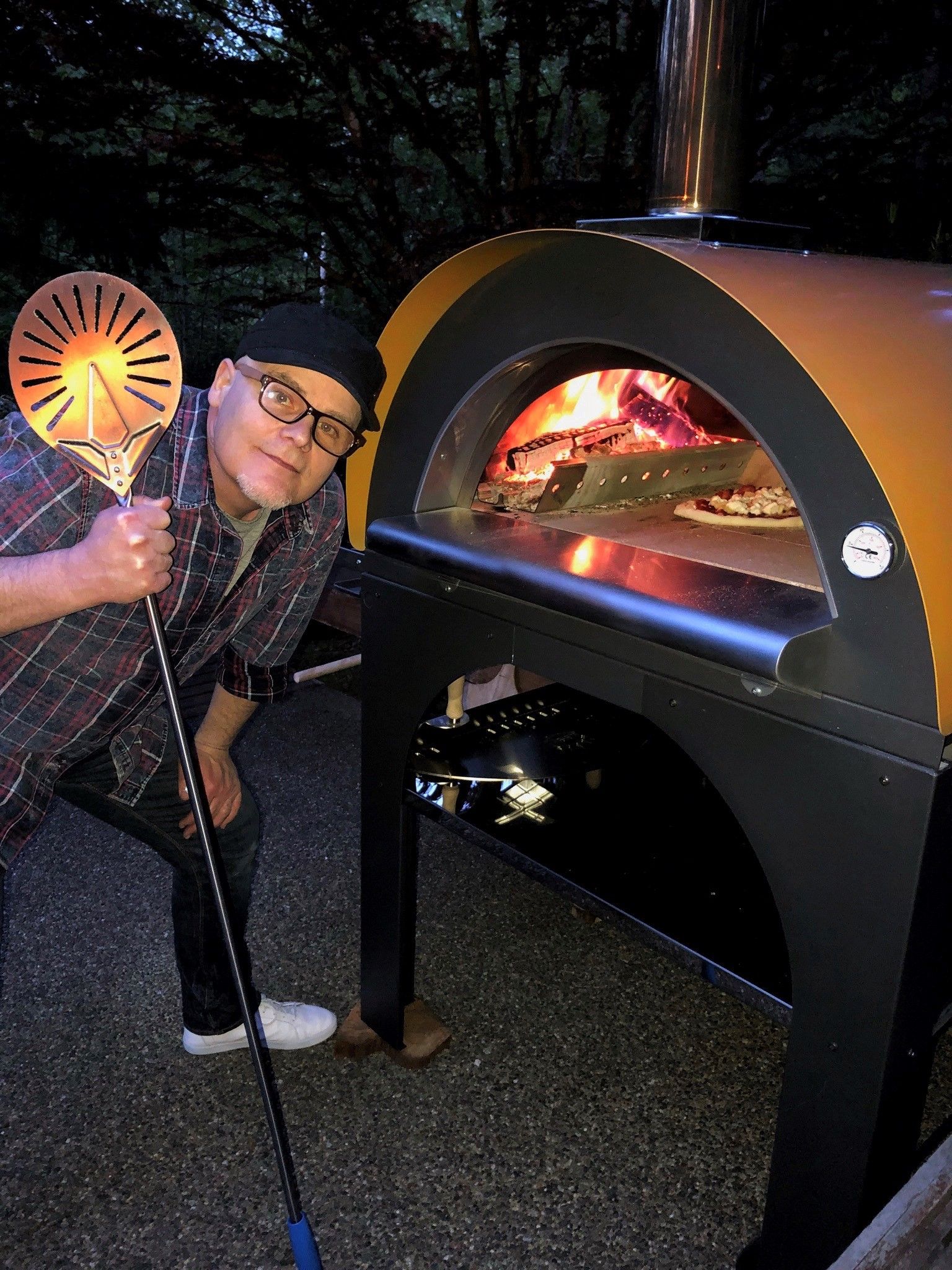 Robbie holding a pizza peel, making pepperoni pizza.